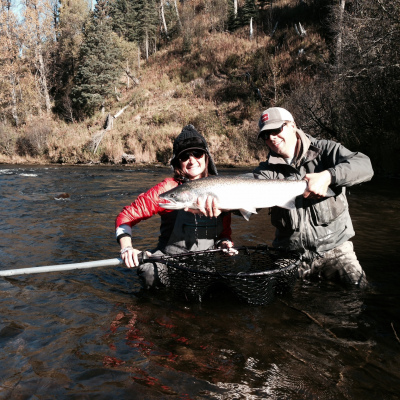 Two anglers hoist a large Steelhead