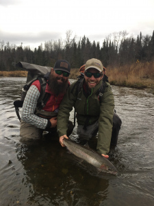 Two happy anglers letting Steelhead go