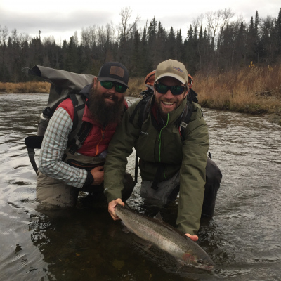 Two happy anglers letting Steelhead go