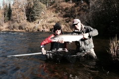 Two anglers hoist a large Steelhead