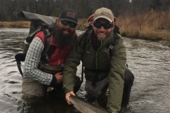 Two happy anglers letting Steelhead go